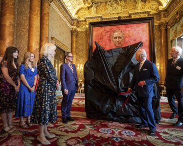 Britain's King Charles III and Queen Camilla at the unveiling of artist Jonathan Yeo's portrait of the King, in the blue drawing room at Buckingham Palace, in London, Tuesday May 14, 2024. The portrait was commissioned in 2020 to celebrate the then Prince of Wales's 50 years as a member of The Drapers' Company in 2022. The artwork depicts the King wearing the uniform of the Welsh Guards, of which he was made Regimental Colonel in 1975. The canvas size - approximately 8.5 by 6.5 feet when framed - was carefully considered to fit within the architecture of Drapers' Hall and the context of the paintings it will eventually hang alongside. (Aaron Chown/Pool Photo via AP)