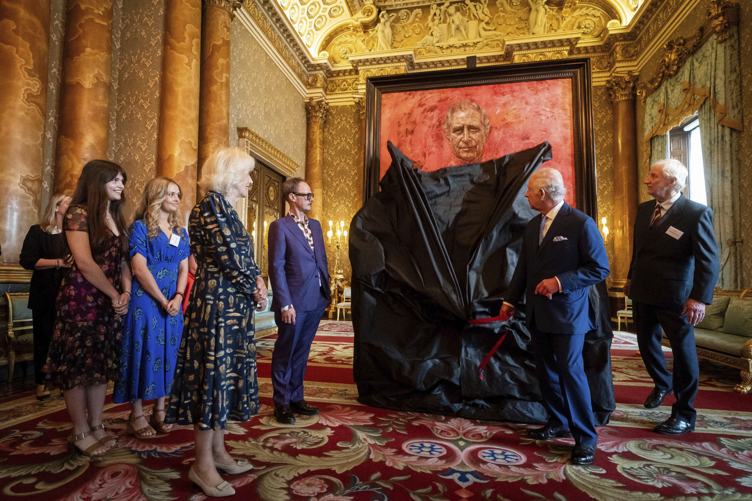 Britain's King Charles III and Queen Camilla at the unveiling of artist Jonathan Yeo's portrait of the King, in the blue drawing room at Buckingham Palace, in London, Tuesday May 14, 2024. The portrait was commissioned in 2020 to celebrate the then Prince of Wales's 50 years as a member of The Drapers' Company in 2022. The artwork depicts the King wearing the uniform of the Welsh Guards, of which he was made Regimental Colonel in 1975. The canvas size - approximately 8.5 by 6.5 feet when framed - was carefully considered to fit within the architecture of Drapers' Hall and the context of the paintings it will eventually hang alongside. (Aaron Chown/Pool Photo via AP)
