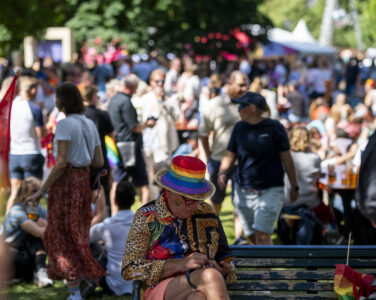 Oslo 20240629. En person med pride hatt sitter på en benk i Sofienberg parken hvor Pride Park blir arrangert etter. Pride-paraden, som feirer skeivt mangfold, markerer uoppnådde rettigheter og forsvarer eksisterende rettigheter, går fra Grønland til Pride Park i Sofienbergparken i Oslo lørdag. (Foto: Frederik Ringnes/NTB.)