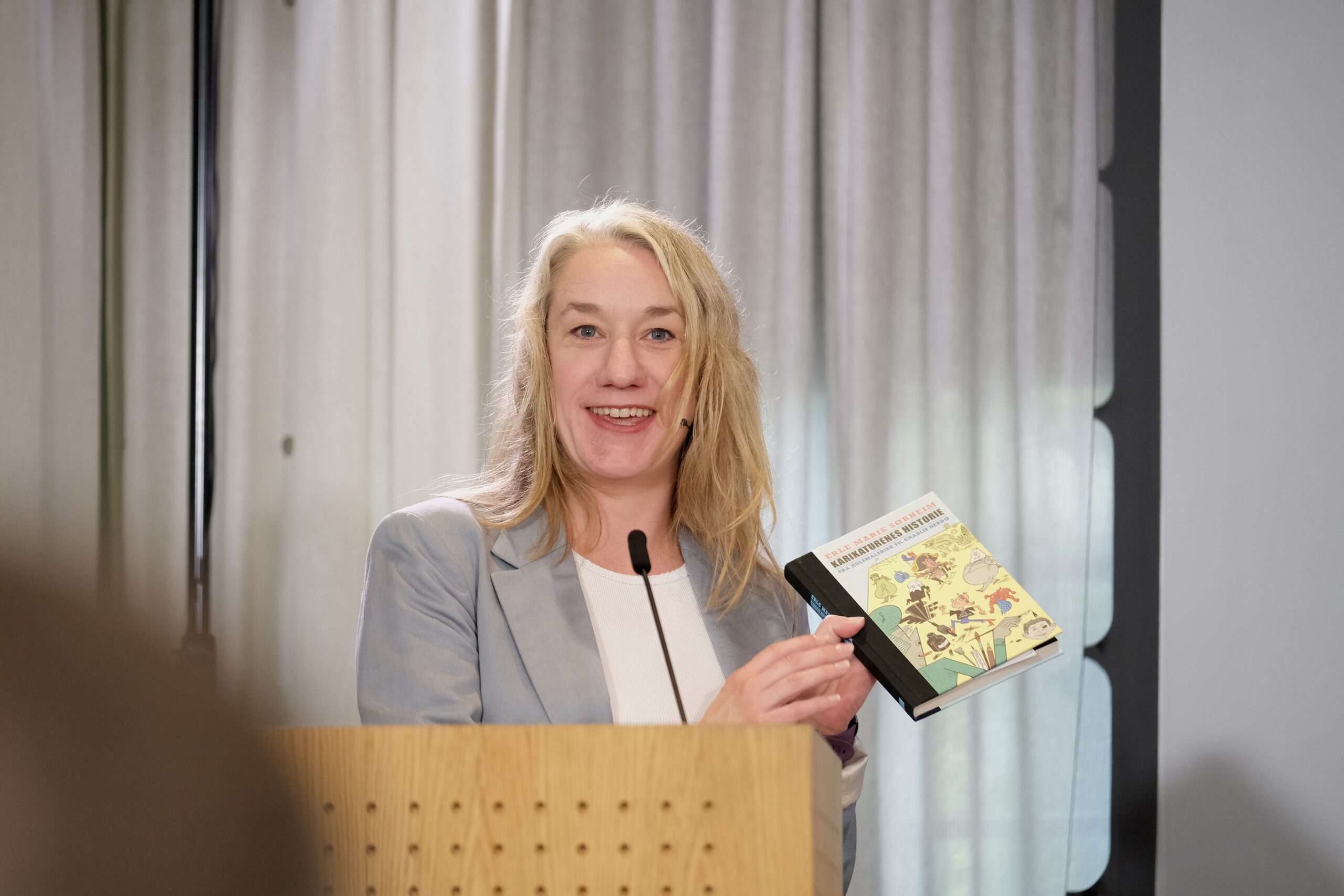 Journalist og forfatter Erle Marie Sørheim holdt et foredrag om karikaturtegninger da regjeringen lanserte sin strategi for ytringsfrihet. Sørheim viste blant annet de omstridte Muhammed-karikaturene fra 2005 – men tegningene var tilsynelatende fjernet fra regjeringens strømming av arrangementet. (Foto: Geir Bergersen Huse.)