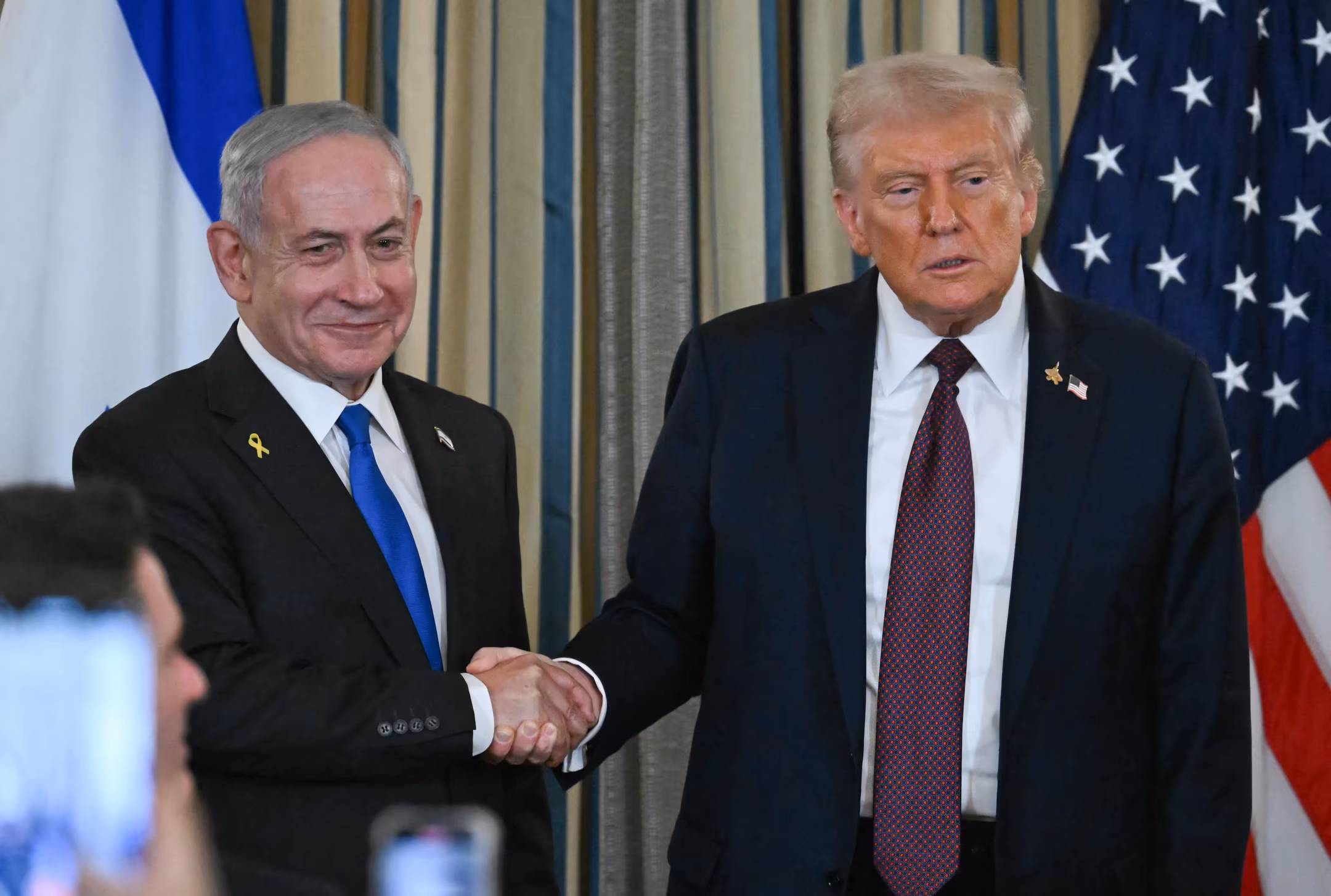 En kontroversiell, straffedømt 78-åring med spraytan fra reality-TV: Nå har han også bidratt til en fredsavtale mellom Israel og Hamas. Ved siden av: Israels statsminister Benjamin Netanyahu. (Foto: AFP.)