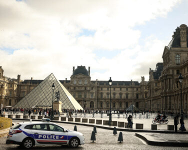 En politibil utenfor Louvre-museet i Paris søndag, en uke etter det spektakulære tyveriet. (Foto: Thomas Padilla/AP/NTB.)