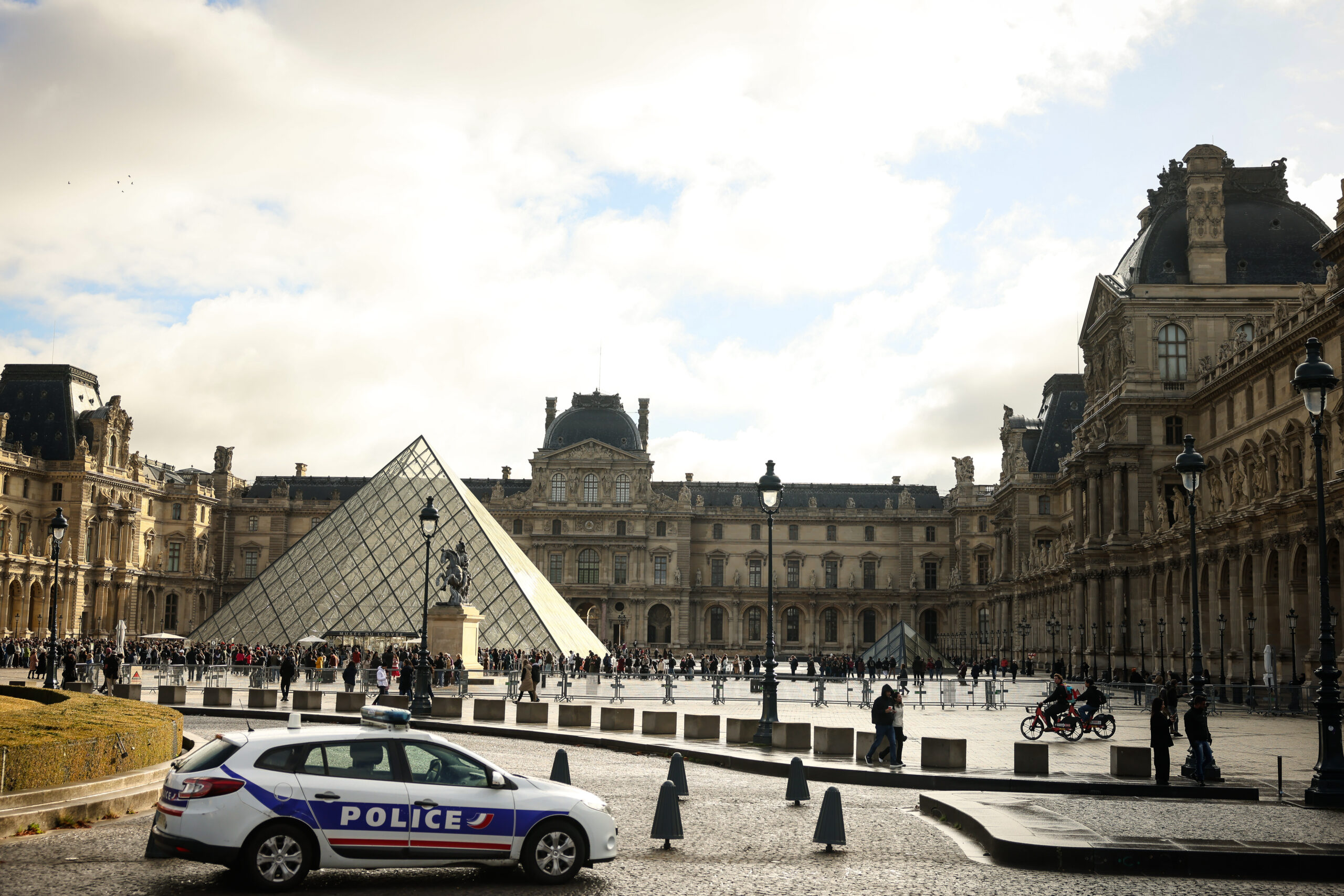 En politibil utenfor Louvre-museet i Paris søndag, en uke etter det spektakulære tyveriet. (Foto: Thomas Padilla/AP/NTB.)