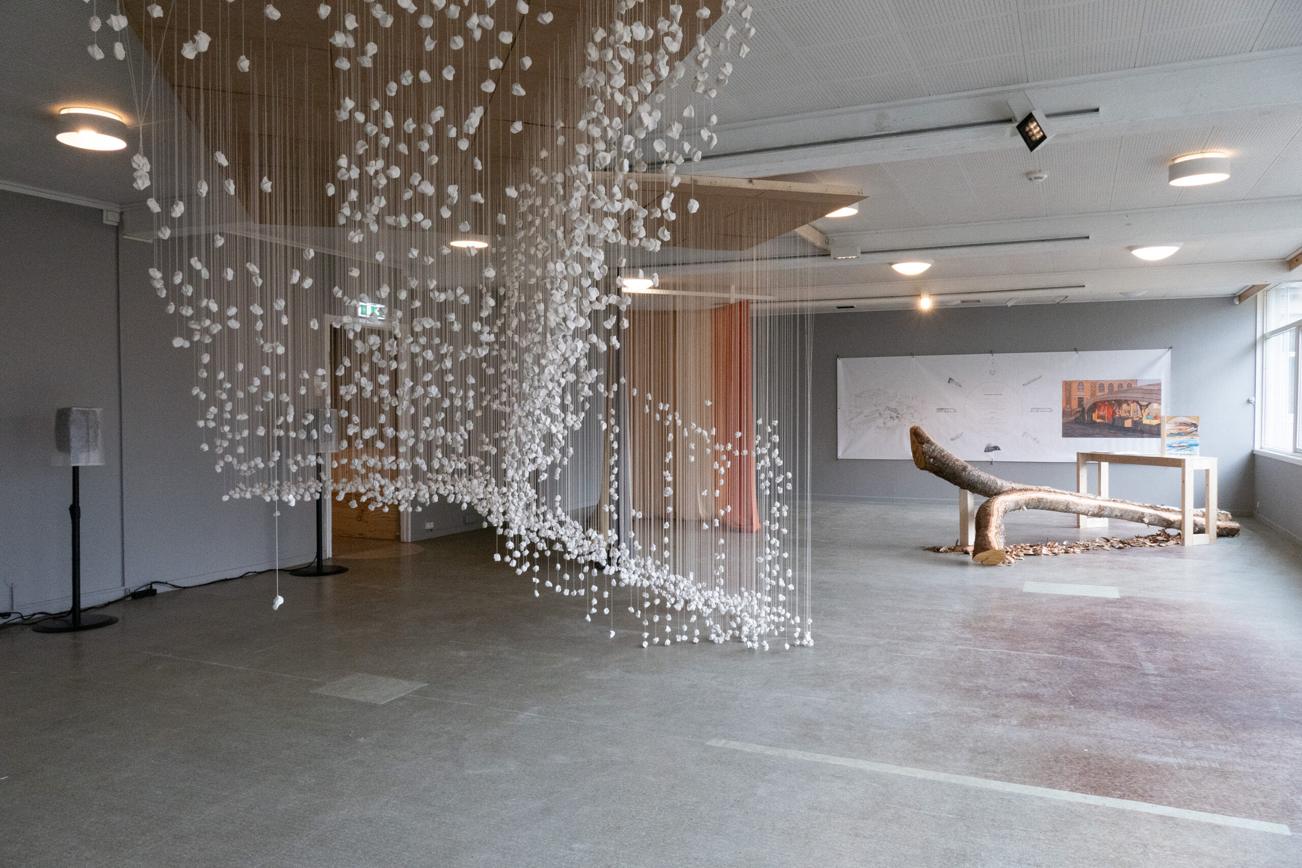 I front: «Jeg var her» (2025) av Kåre Aleksander Grundvåg og Alexander Rishaug, til venstre bak tekstil: «Fargeprismer fra naturen» (2025) av Hilde Hauan Johnsen, og til høyre bak: «Kokegamme» (2025) av Joar Nango, og fettstifttegninger av Marit Bockelie, Eystein Talleraas, Arne-Terje Sæther. (Foto: Kai Mørk Mortensen.)