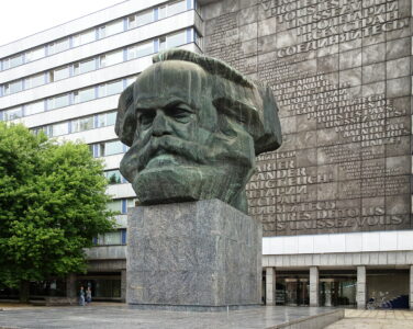 Karl Marx forklarer priser som et resultat av arbeidstiden tilført produksjonen av et produkt. I liberalismen avfeies denne teorien. På bildet: En byste av Karl Marx i den tyske byen Chemnitz. (Foto: Wikimedia commons.)