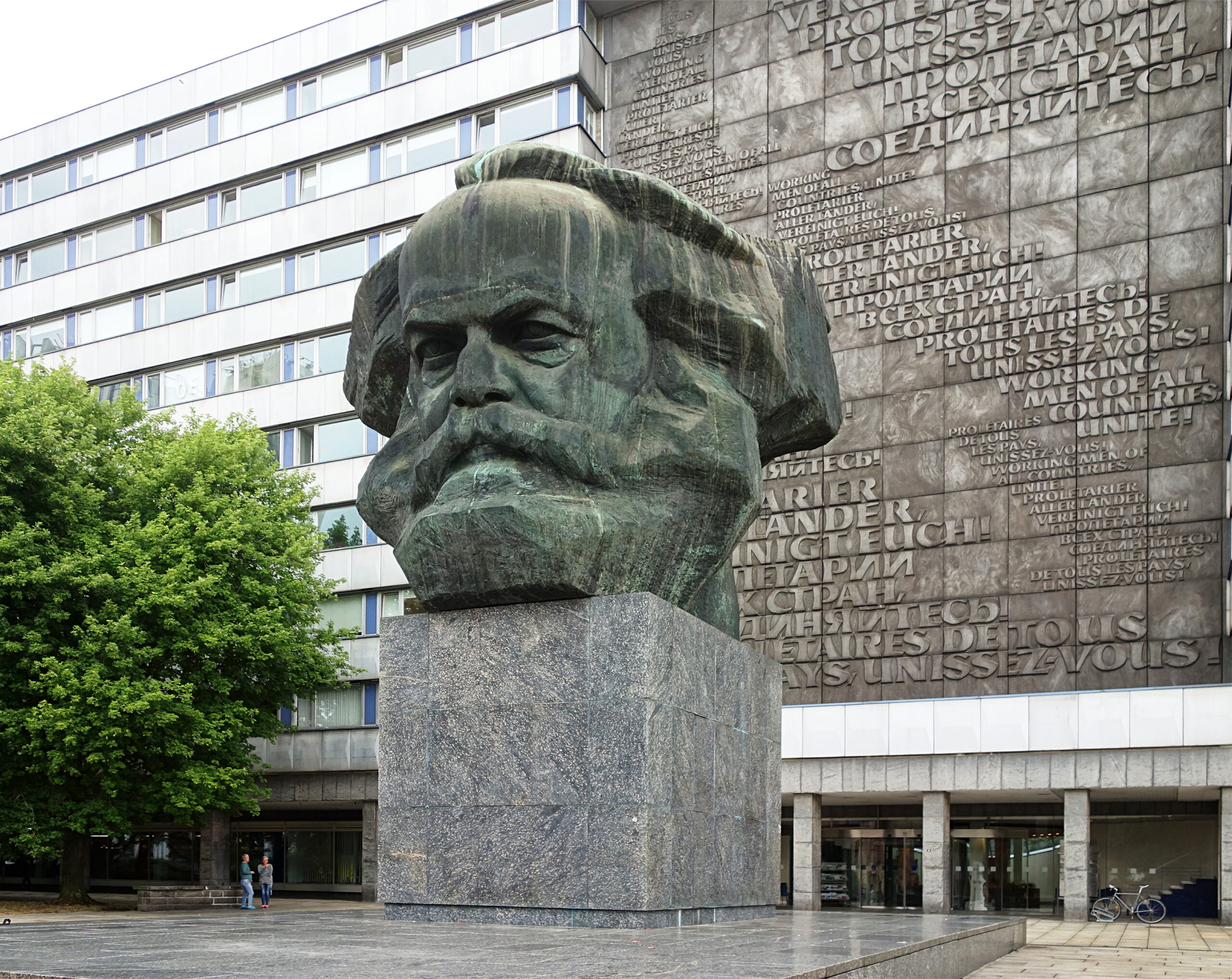 Karl Marx forklarer priser som et resultat av arbeidstiden tilført produksjonen av et produkt. I liberalismen avfeies denne teorien. På bildet: En byste av Karl Marx i den tyske byen Chemnitz. (Foto: Wikimedia commons.)