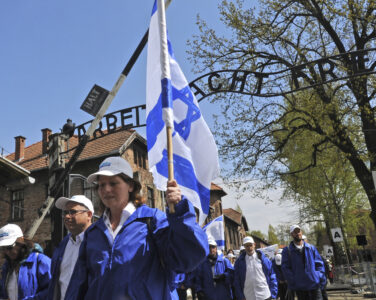 Participants of the yearly March of the Living walk through the "Arbeit Macht Frei" (work sets you free) entrance gate in the former German Nazi Death Camp Auschwitz-Birkenau, in Oswiecim, Poland, Monday, April 24, 2017. Jews from Israel and around the world marched the 3km route from Auschwitz to Birkenau commemorating the Holocaust victims. (AP Photo/Alik Keplicz)