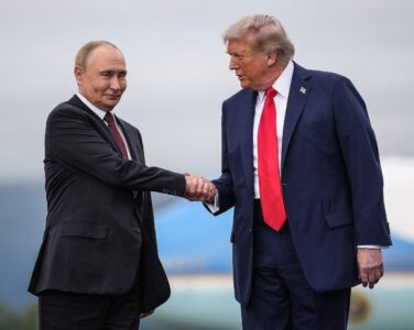 Donald Trump og Vladimir Putin tar hverandre i henda. (Foto: Andrew Harnik/Getty.)