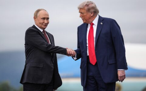 Donald Trump og Vladimir Putin tar hverandre i henda. (Foto: Andrew Harnik/Getty.)