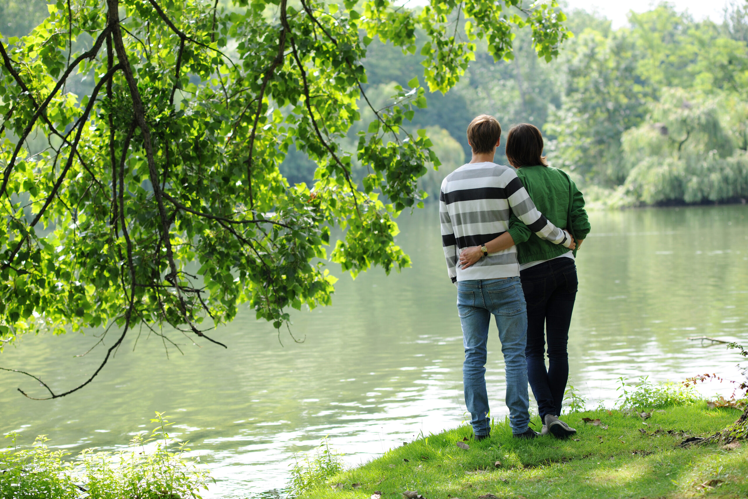 Ungt forelsket par i naturen. Sommerforelskelse. Ung kjærlighet. Forelskelse. Forelsket. Ung kvinne. Ung mann. Lykke. Nyter livet. Livsnyter. Tenåringer. Ser ut over vannet. Stripete genser. Melankoli. Drømmer. Drømmende. Fremtid. Fremtiden. Håp. Melankolsk. Young couple out in nature. (Modellklarert illustrasjonsfoto: Frank May/NTB.)