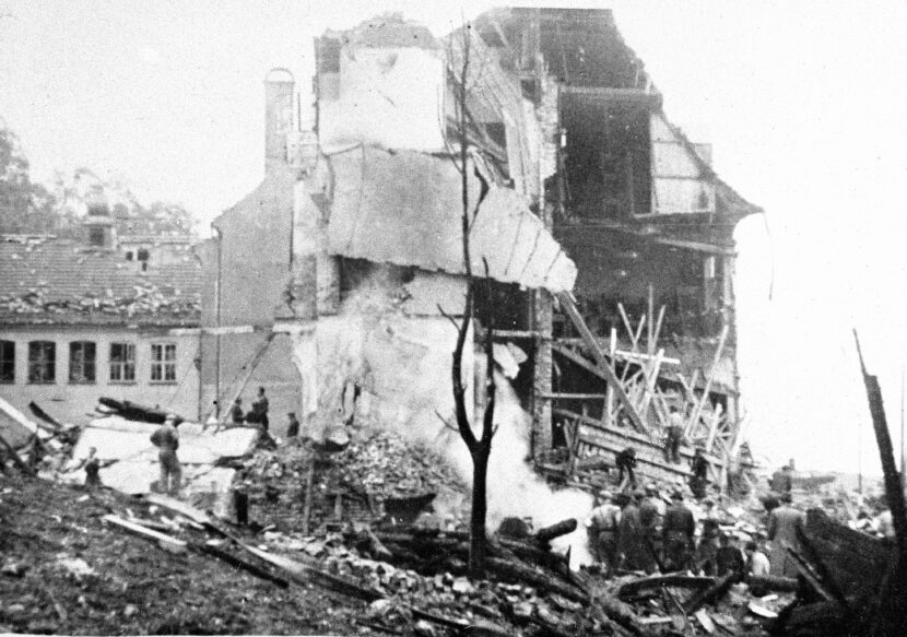 Norge under tysk okkupasjon. Alliert / britisk bombeangrep på ubåtbunkeren på Laksevåg ved Bergen 4. oktober 1944. Store sivile tap, over 200 omkom i flyangrepet . Ubåtbunkeren ble ikke skadet. Holen skole ble bombet, og 61 elever og 14 voksne omkom. Ruinene av skolen, redningsmannskap i arbeid.