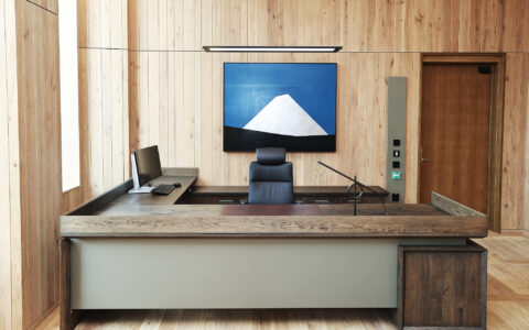 Statsministerens skrivebord er utført i sørlandskeik og eloksert norsk aluminium med ett nedfelt skriveunderlag av norsk reinsdyrskinn. Møblet har fått en overflatebehandling som gjør at de fremstår litt mørkere i farge. Reinsdyrskinnet er levert av Granberg garveri (Ølensvåg, Rogaland). Håndtak på skuffer tar opp samme designspråk som fasade og parkett. Bordet er designet av Team Urbis og bygget av Hamran. Foto: Torbjørn Kjosvold / SMK