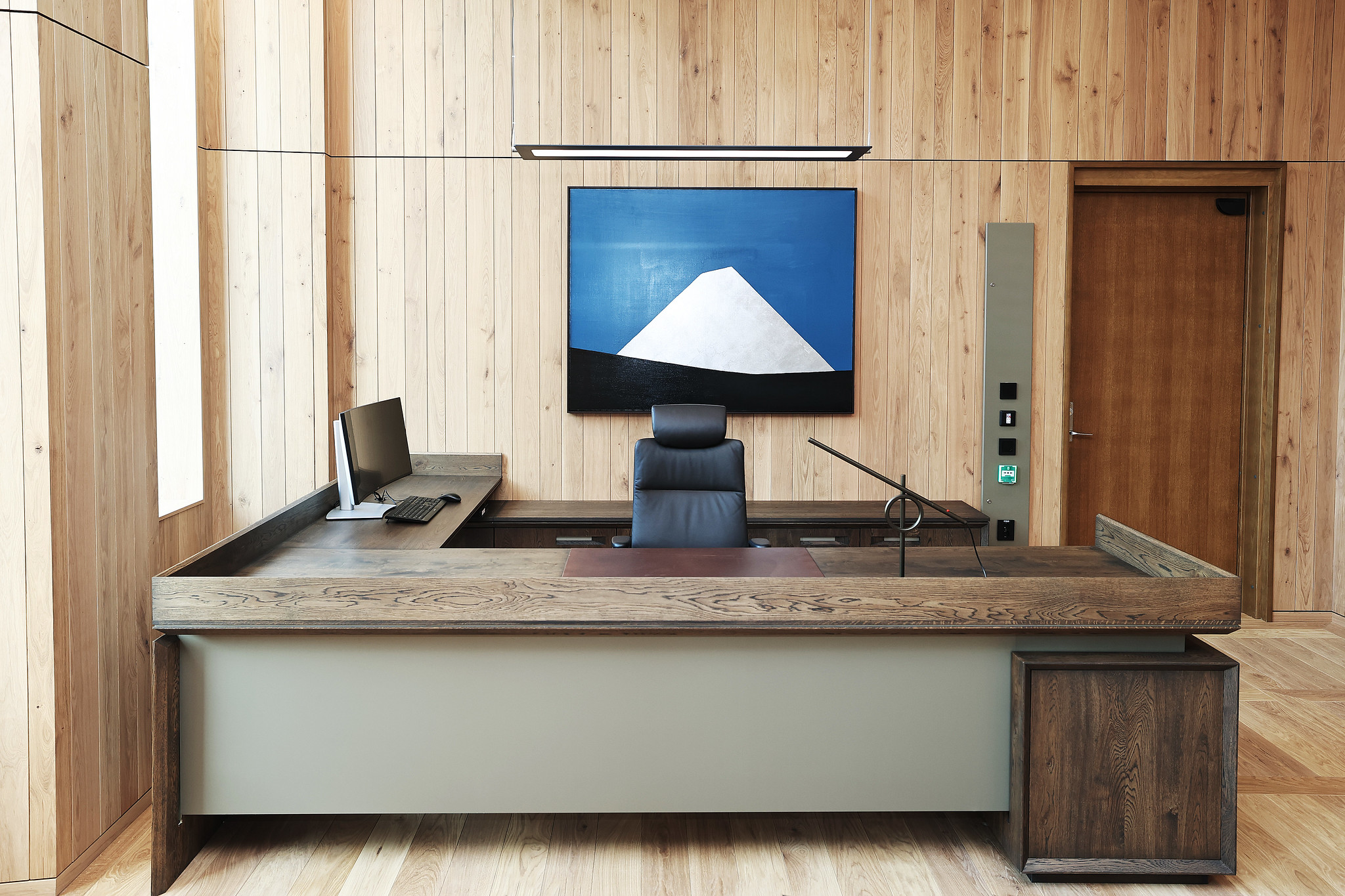 Statsministerens skrivebord er utført i sørlandskeik og eloksert norsk aluminium med ett nedfelt skriveunderlag av norsk reinsdyrskinn. Møblet har fått en overflatebehandling som gjør at de fremstår litt mørkere i farge. Reinsdyrskinnet er levert av Granberg garveri (Ølensvåg, Rogaland). Håndtak på skuffer tar opp samme designspråk som fasade og parkett. Bordet er designet av Team Urbis og bygget av Hamran. Foto: Torbjørn Kjosvold / SMK