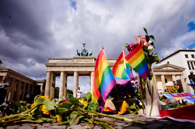 Flowers and rainbow flags placed in front of the Brandenburg Gate commemorating the victims of a car attack on Saturday's Pride March in Berlin, Germany, Monday, July 27, 2026. (Foto: AP/Markus Schreiber.)