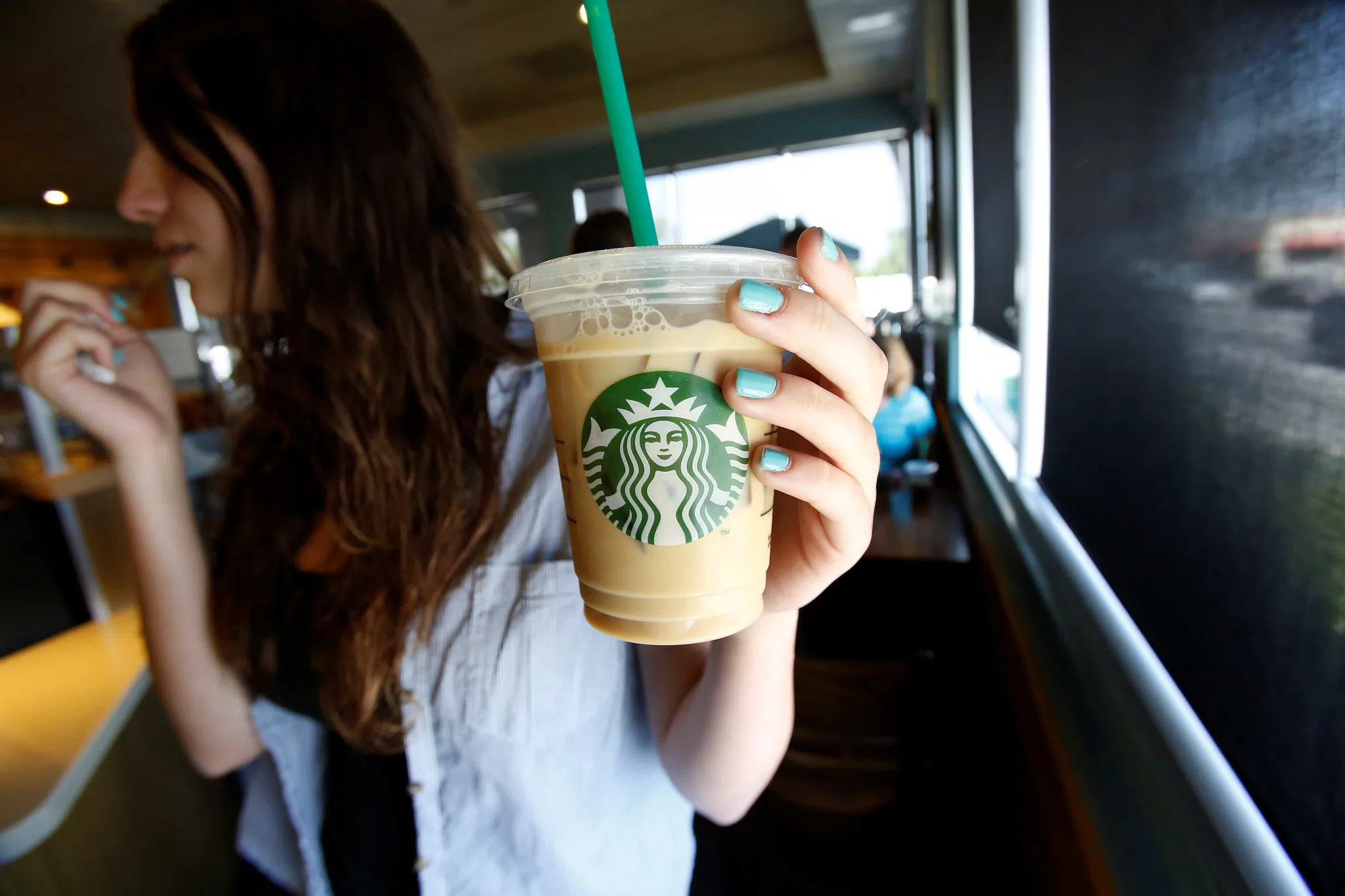 Kvinne på Starbucks drikker kaffe med sugerør. (Foto: Reuters.)