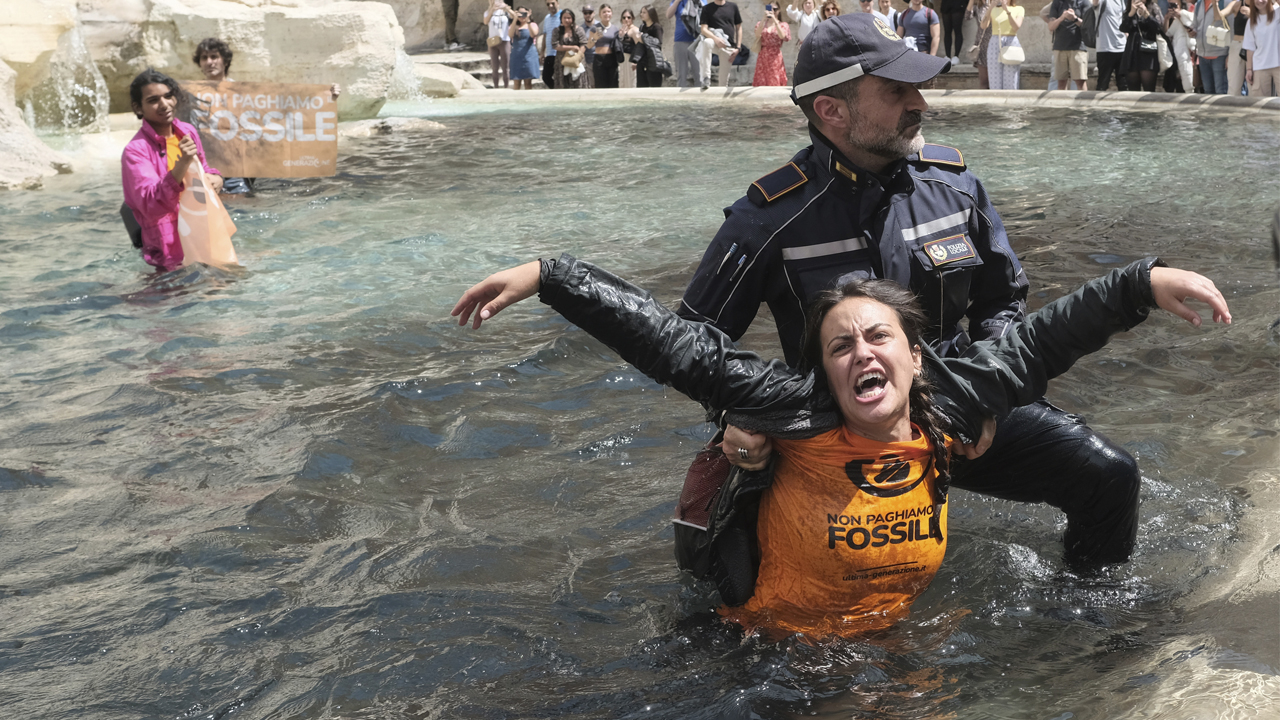 En av demonstrantene slepes ut av Trevi-fontenen i Roma av politiet. (Foto: Mauro Scrobogna.)